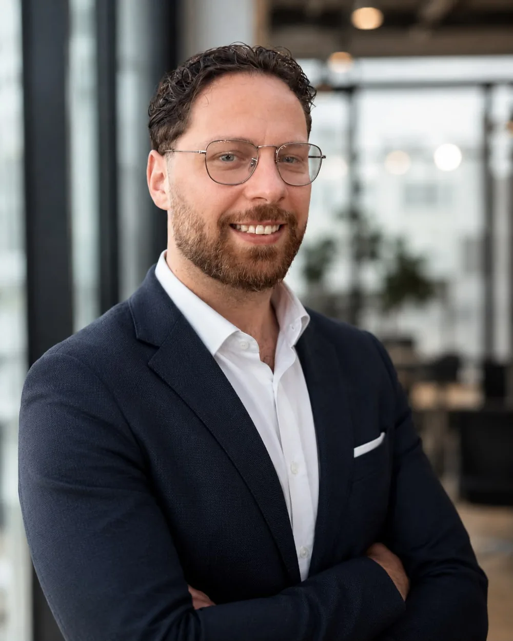 Daniel Wudernitz, Inhaber von Wundernitz AI Studio — Porträtfoto vor einer Fensterfront im Büro.